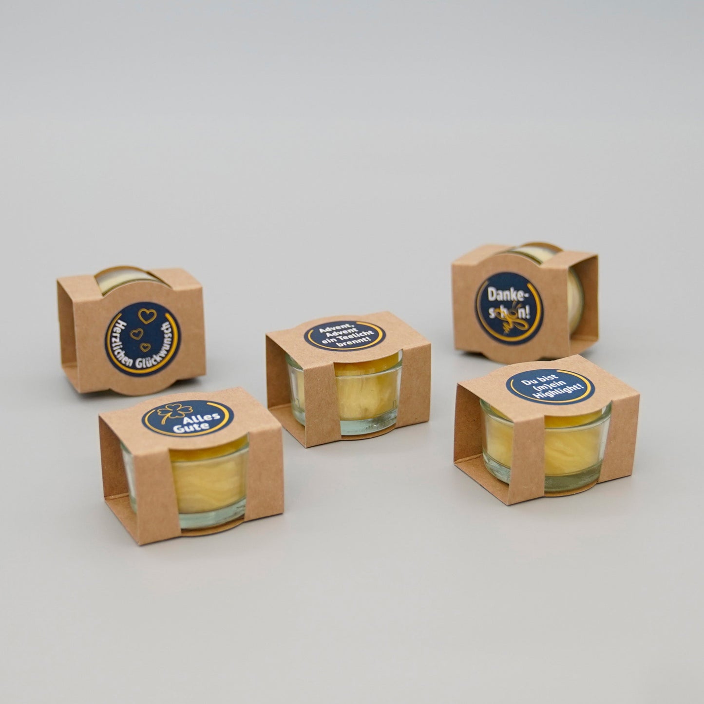 fünf verpackte Teelichte mit unterschiedlichen Aufschriften