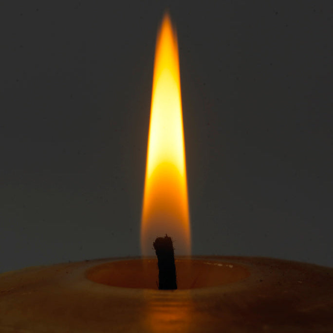 Flamme einer brennenden Bienenwachskerze